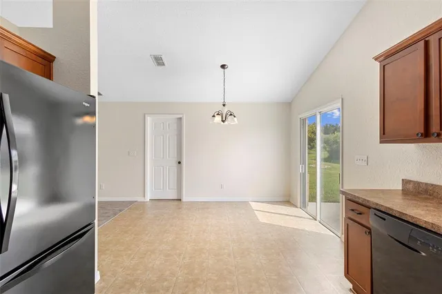 a view of a kitchen with granite countertop a refrigerator and a sink