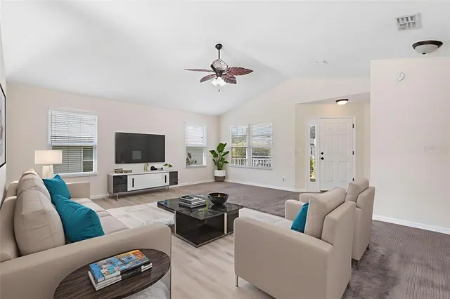 a living room with furniture a flat screen tv and a couch