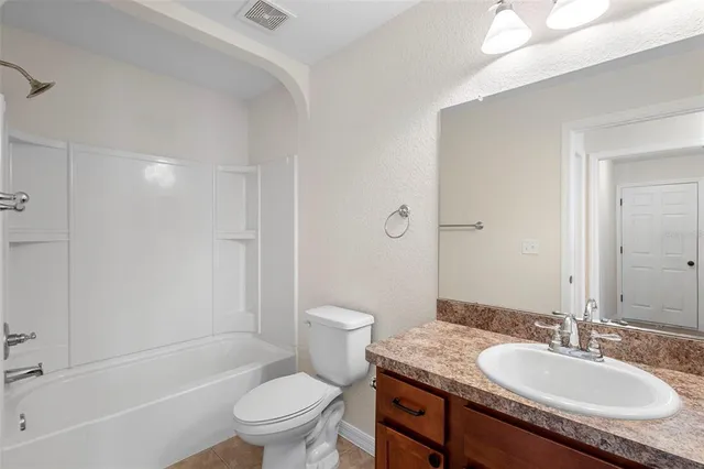 a bathroom with a granite countertop sink a toilet and shower