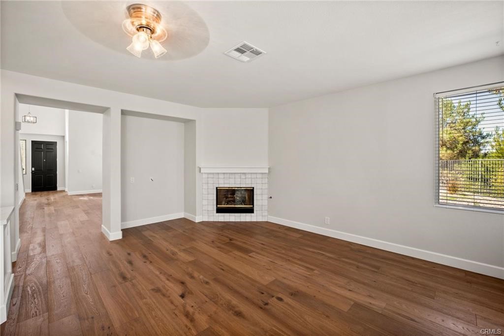 30840 Point Woods Court Temecula, CA 92591 - Photo 15 of 35 an empty room with wooden floor fireplace and windows