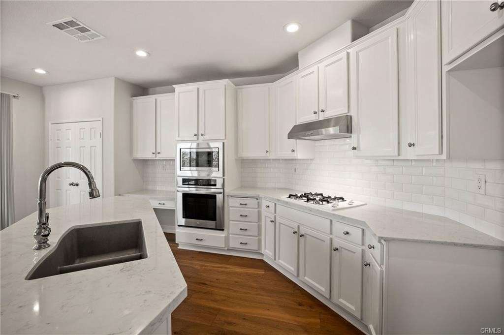 30840 Point Woods Court Temecula, CA 92591 - Photo 10 of 35 a kitchen with stainless steel appliances granite countertop a stove sink and cabinets