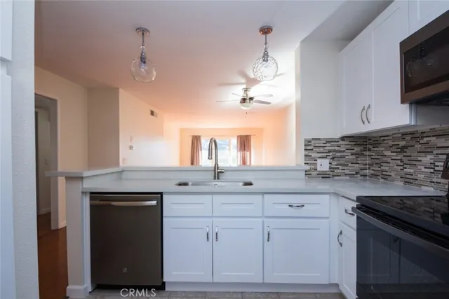 a kitchen with white cabinets and appliances