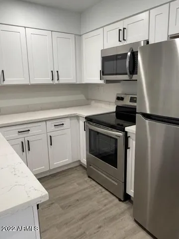 a kitchen with white cabinets and stainless steel appliances