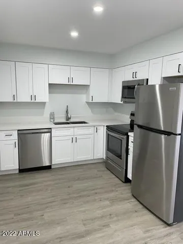 a kitchen with white cabinets and white appliances