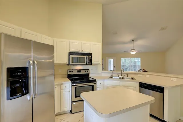a kitchen with a sink stainless steel appliances and white cabinets