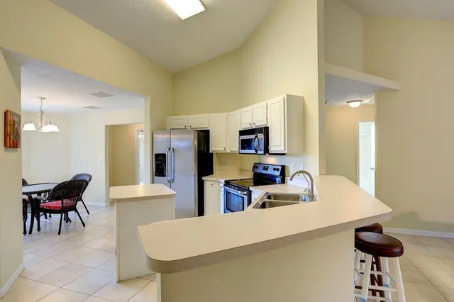 a kitchen with stainless steel appliances kitchen island granite countertop a sink and a refrigerator