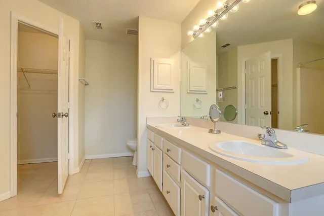 a spacious bathroom with a double vanity sink mirror and double