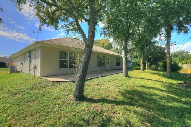 a view of a house with backyard and tree