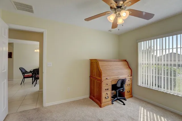 a view of a workspace with furniture and a window