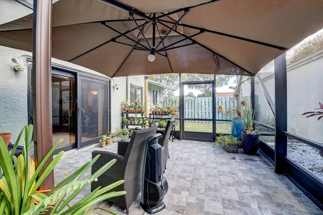a view of a patio with table and chairs under an umbrella
