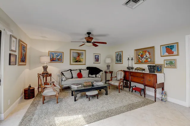 a living room with furniture a rug and a wall painting