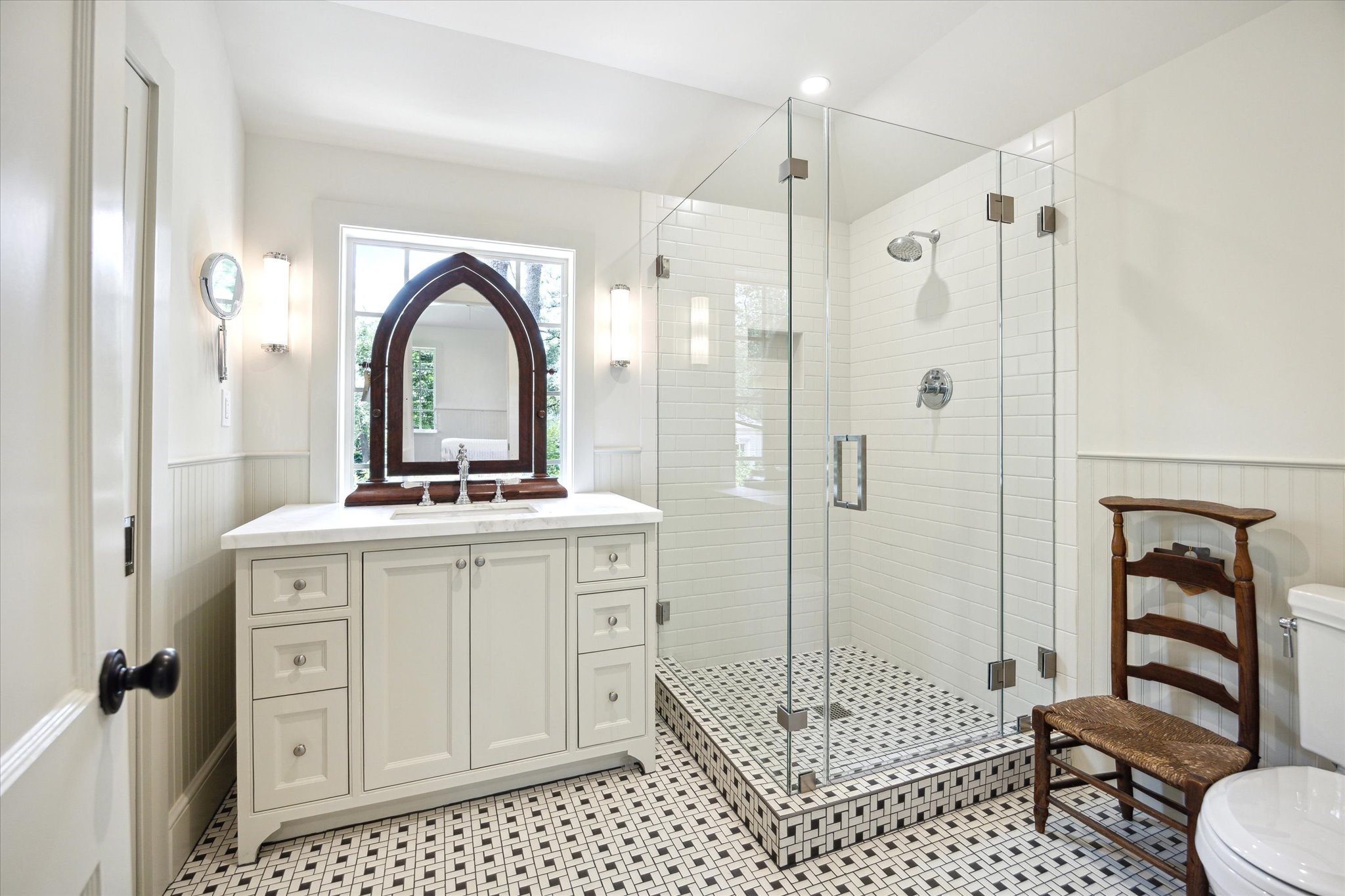 4019 Inverness Drive Houston, TX 77019 - Photo 39 of 49 The en suite bath showcases a marble vanity, walk-in shower, beadboard walls, tile floors, and layered recessed and vanity lighting.