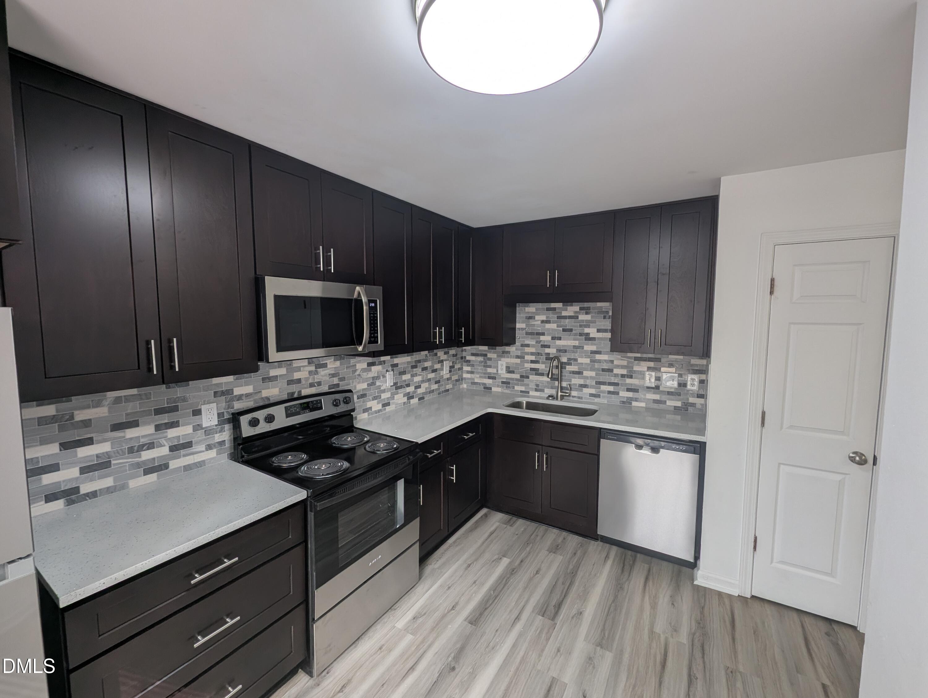 1005 Shades Place Raleigh, NC 27601 - Photo 6 of 18 a kitchen with stainless steel appliances granite countertop a sink stove and cabinets