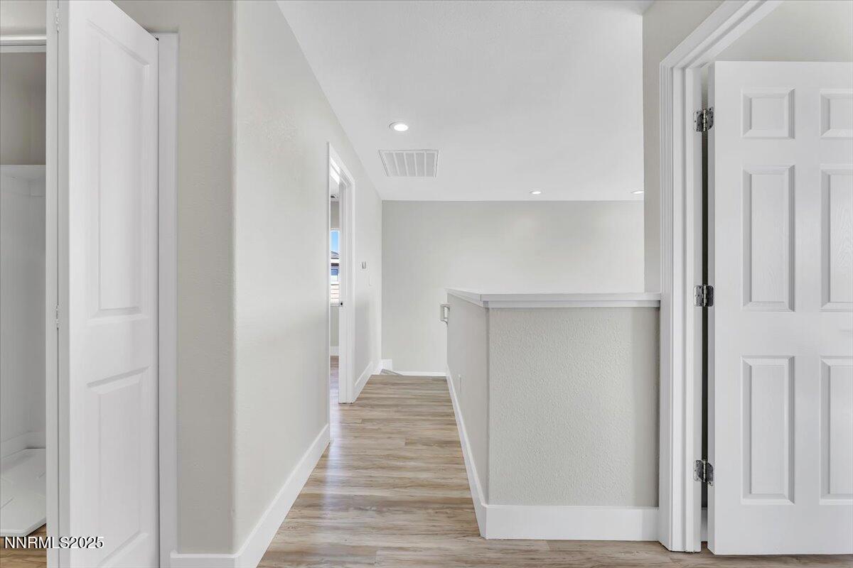 9252 Lone Wolf Circle Reno, NV 89506 - Photo 14 of 26 a view of a hallway with wooden floor and staircase
