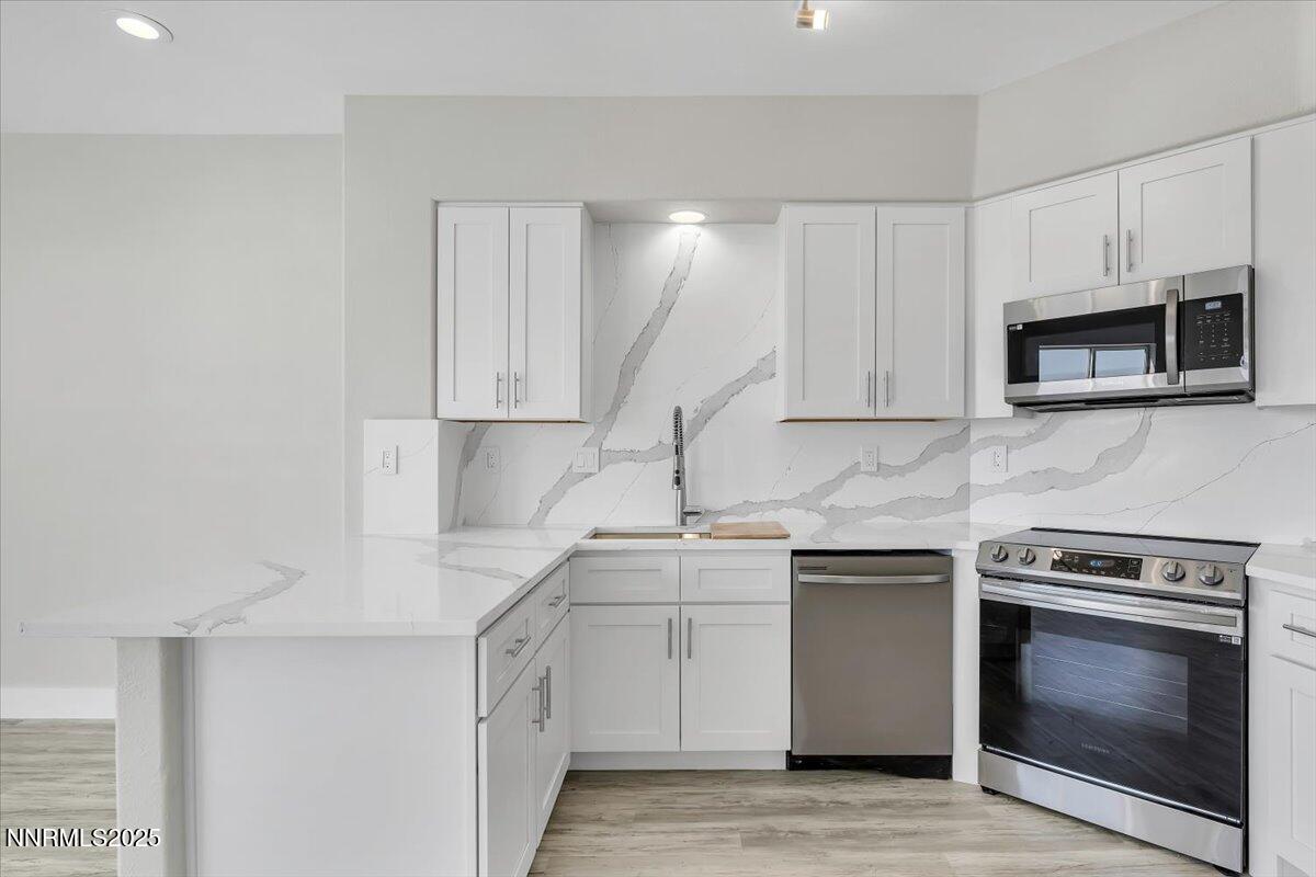 9252 Lone Wolf Circle Reno, NV 89506 - Photo 10 of 26 a kitchen with white cabinets stainless steel appliances and sink