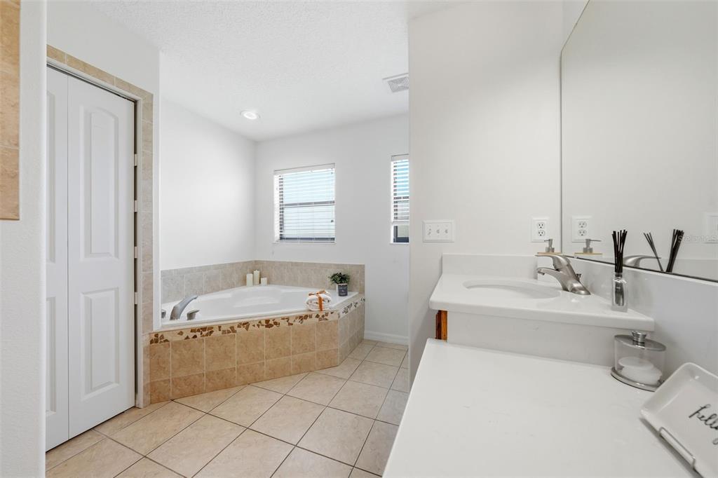 14433 Lake Yale Road Umatilla, FL 32784 - Photo 16 of 38 a bathroom with a tub a sink and a large mirror