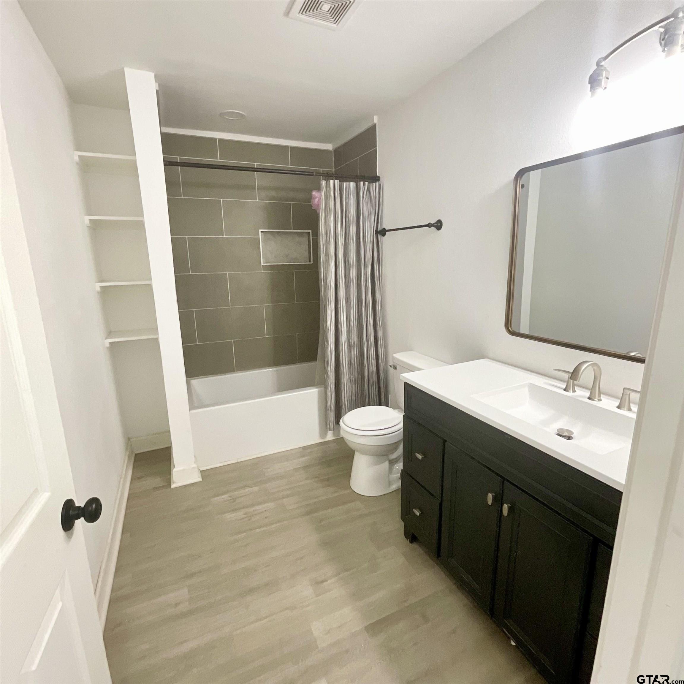 151 Patton Lane Tyler, TX 75704 - Photo 17 of 26 a bathroom with a double vanity sink toilet mirror and shower
