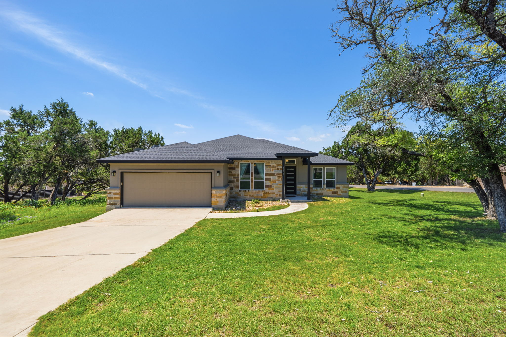 18605 Masters Cove Point Venture, TX 78645 - Photo 1 of 40 Contemporary single-story residence with a stone and stucco exterior
