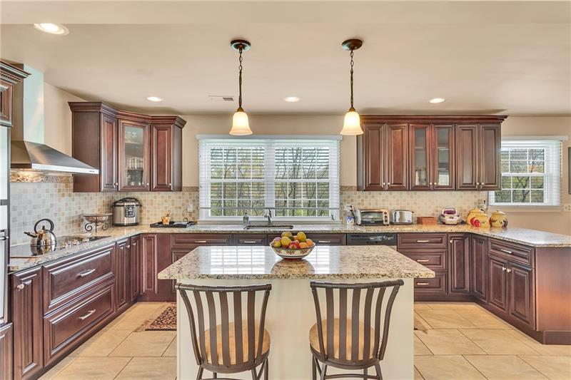 154 Bryson Road Gibsonia, PA 15044 - Photo 4 of 41 a kitchen with stainless steel appliances granite countertop a sink a stove a kitchen island and chairs