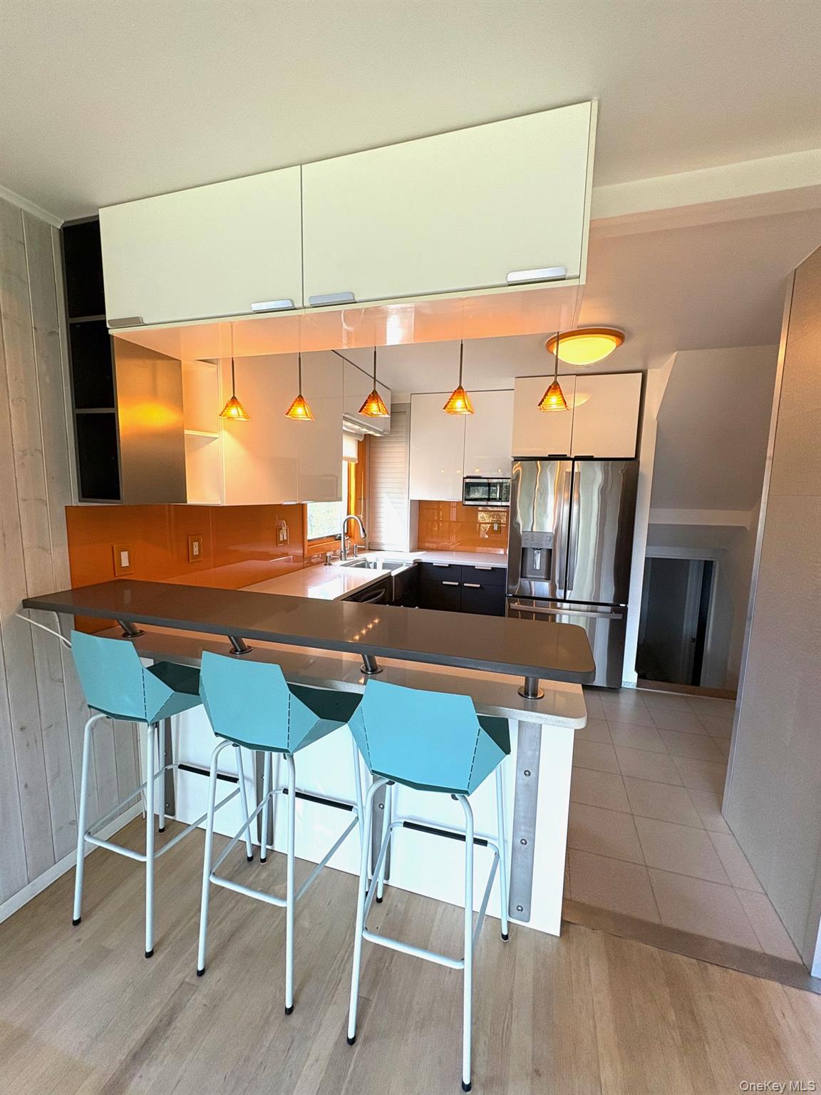 1 Dale Street Rye, NY 10580 - Photo 6 of 28 View of kitchen from dining area shows breakfast bar w/stool seating, pendulum lighting and overhead cabinets.
