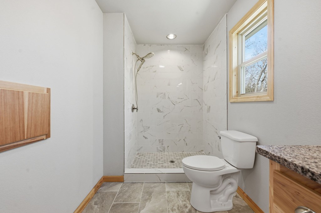 55 Heidis Run Murphy, NC 28906 - Photo 35 of 53 a bathroom with a granite countertop toilet a sink and a shower