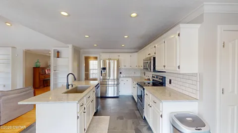 a kitchen with white cabinets and sink