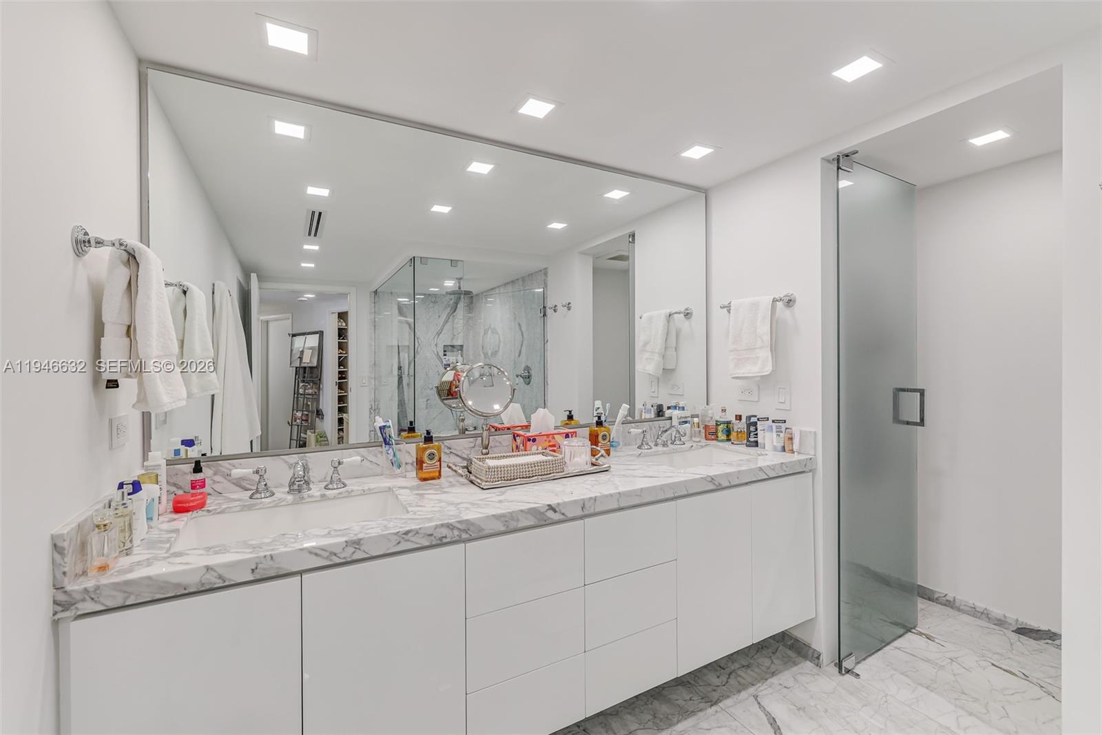 1121 Crandon Boulevard, Unit F802 Key Biscayne, FL 33149 - Photo 18 of 36 a bathroom with double vanity sinks and a mirror