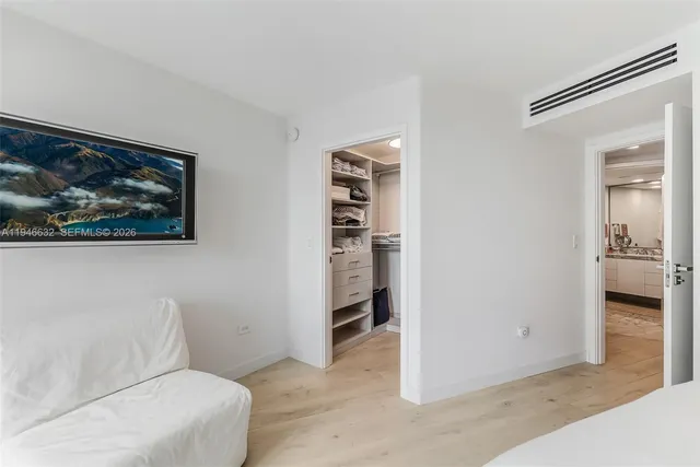 a hallway with closet and a potted plant