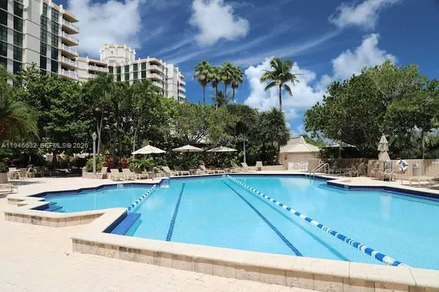 a view of a swimming pool with a lawn chairs under an umbrella