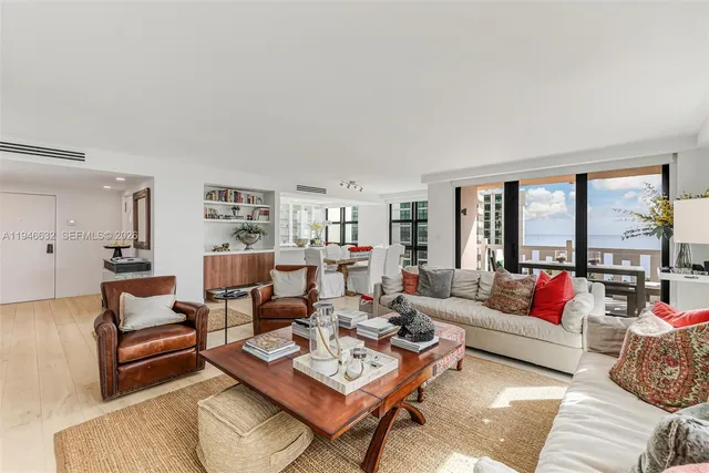 a living room with furniture floor to ceiling window and a table