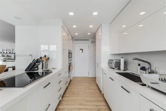 a large white kitchen with stainless steel appliances