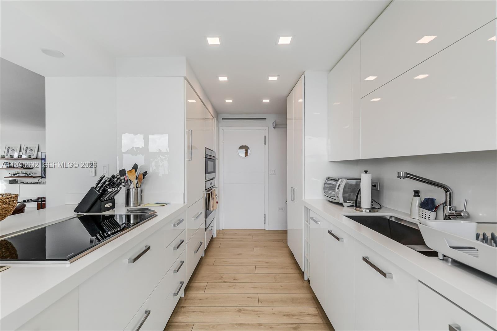 1121 Crandon Boulevard, Unit F802 Key Biscayne, FL 33149 - Photo 8 of 36 a large white kitchen with stainless steel appliances
