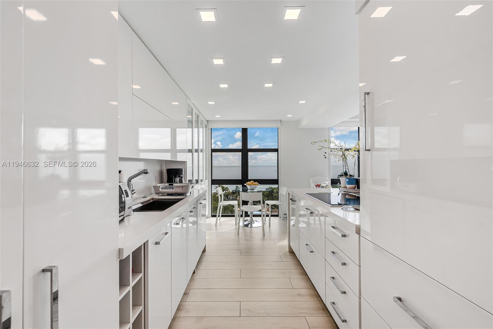 1121 Crandon Boulevard, Unit F802 Key Biscayne, FL 33149 - Photo 9 of 36 a large white kitchen with lots of counter space a sink and appliances