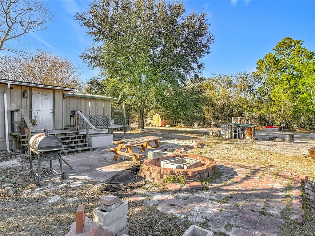 43430 Cooter Pond Road DeLand, FL 32720 - Photo 33 of 37 a view of a patio with table and chairs and potted plants with wooden fence
