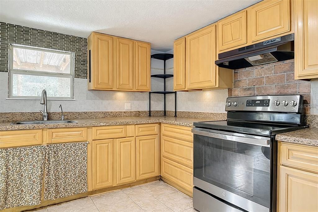 43430 Cooter Pond Road DeLand, FL 32720 - Photo 4 of 37 a kitchen with stainless steel appliances granite countertop a sink stove and cabinets
