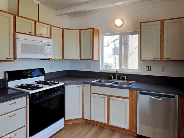 a kitchen with stainless steel appliances granite countertop a sink stove and cabinets