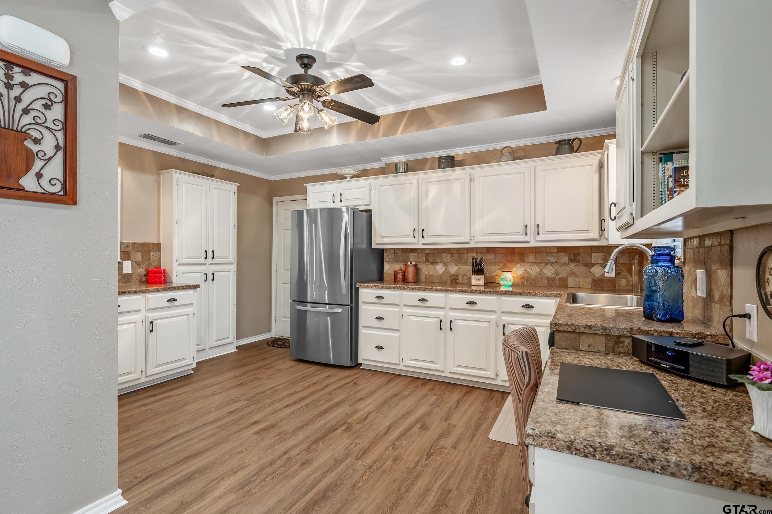 3309 Trafalgar Square Tyler, TX 75701 - Photo 9 of 23 a kitchen with refrigerator cabinets and wooden floor