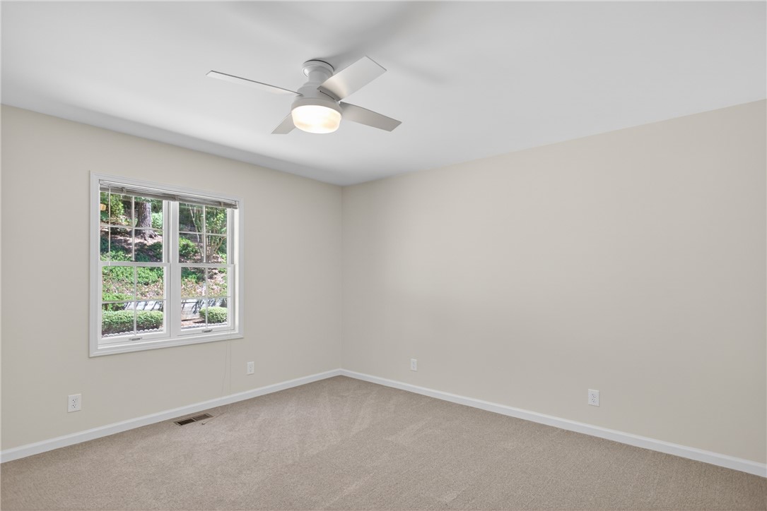 9 Lookout Lane Salem, SC 29676 - Photo 20 of 46 A tranquil bedroom with a large window offering verdant views, complemented by soft carpeting and a ceiling fan.