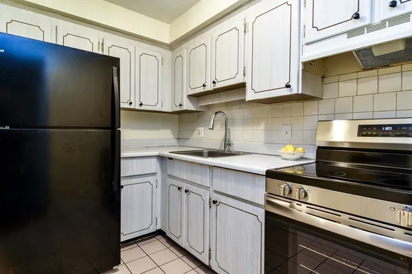 a kitchen with stainless steel appliances granite countertop a refrigerator a stove a sink and cabinets