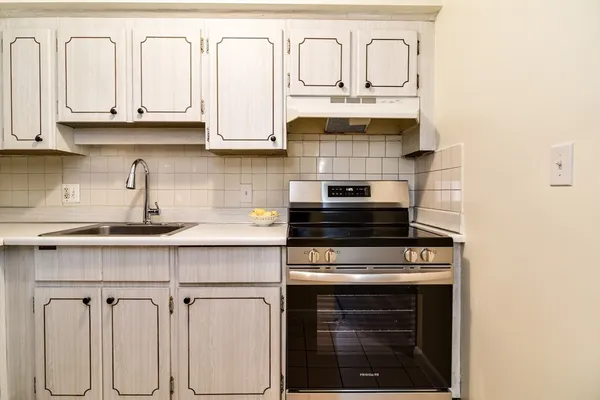 a kitchen with white cabinets and appliances