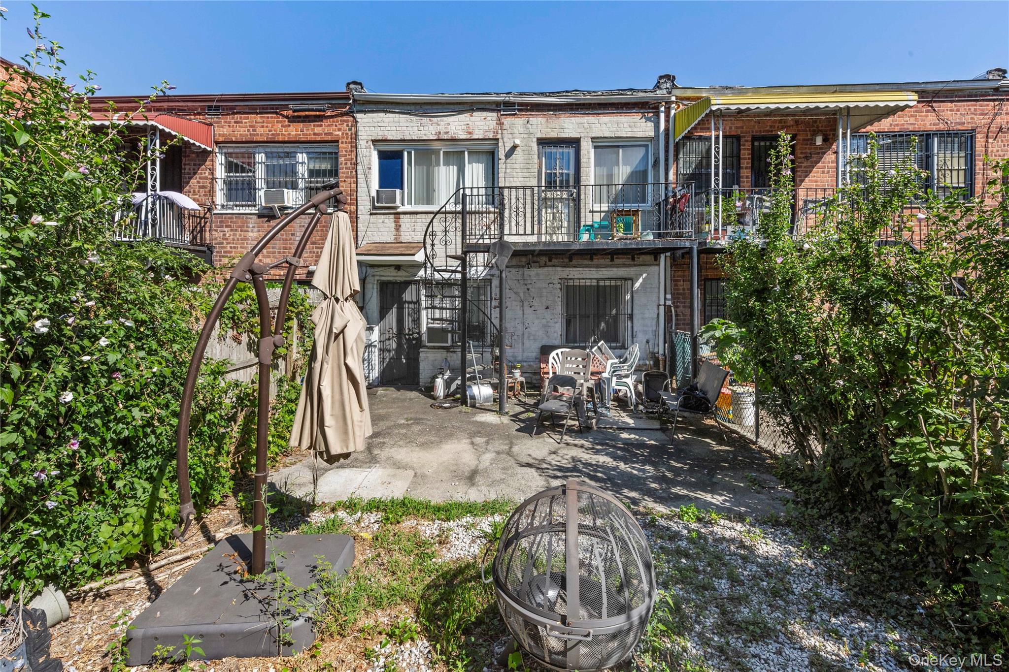 113-66 Springfield Boulevard Queens, NY 11429 - Photo 4 of 5 Back of house featuring brick siding, a balcony, a patio area, and stairs