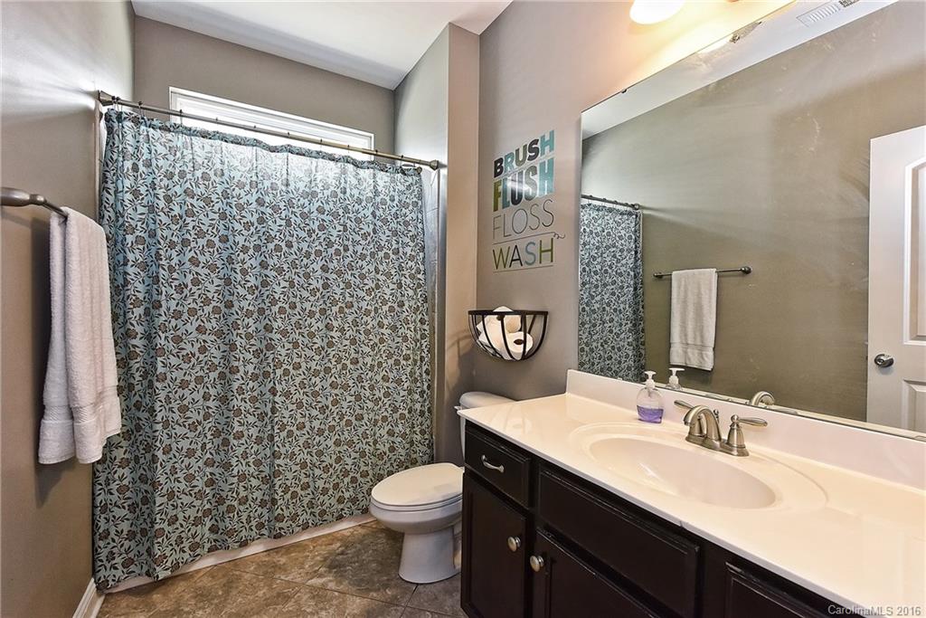3004 Fallondale Road, Unit 906 Waxhaw, NC 28173 - Photo 17 of 24 a bathroom with a sink a toilet a shower and a mirror