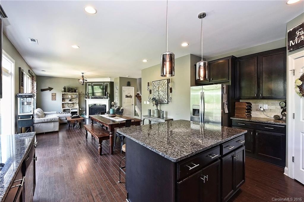 3004 Fallondale Road, Unit 906 Waxhaw, NC 28173 - Photo 10 of 24 a kitchen with granite countertop kitchen island stainless steel appliances a table chairs sink and refrigerator