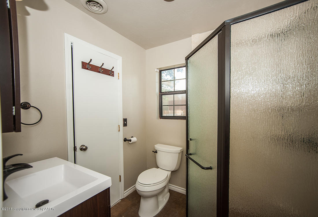 4610 South Lamar Street Amarillo, TX 79110 - Photo 3 of 10 a bathroom with a sink a toilet and shower
