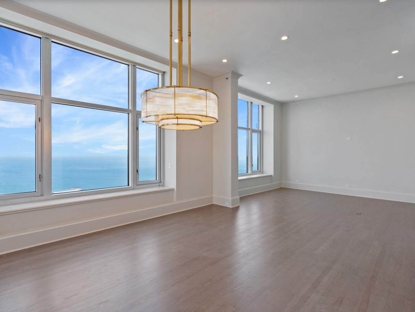 132 East Delaware Place, Unit 620507 Chicago, IL 60611 - Photo 3 of 22 a view of an empty room with window and wooden floor