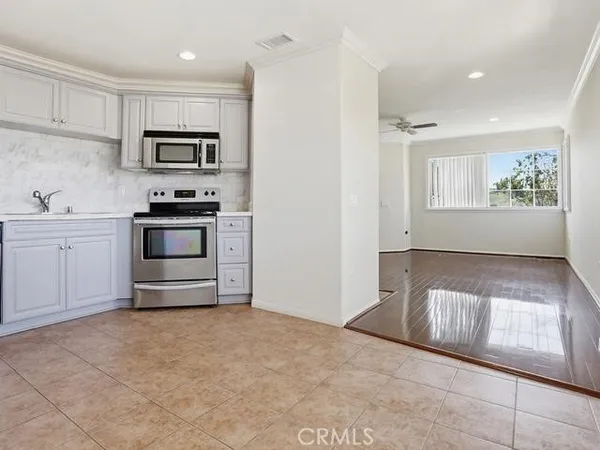 a kitchen with cabinets stainless steel appliances and a counter space