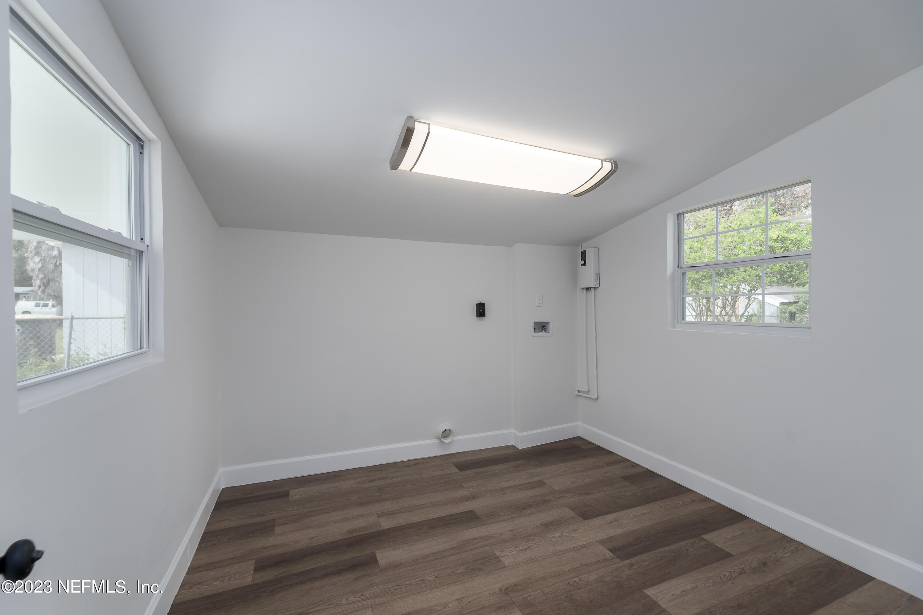 7425 Centauri Road Jacksonville, FL 32210 - Photo 11 of 23 an empty room with wooden floor and windows