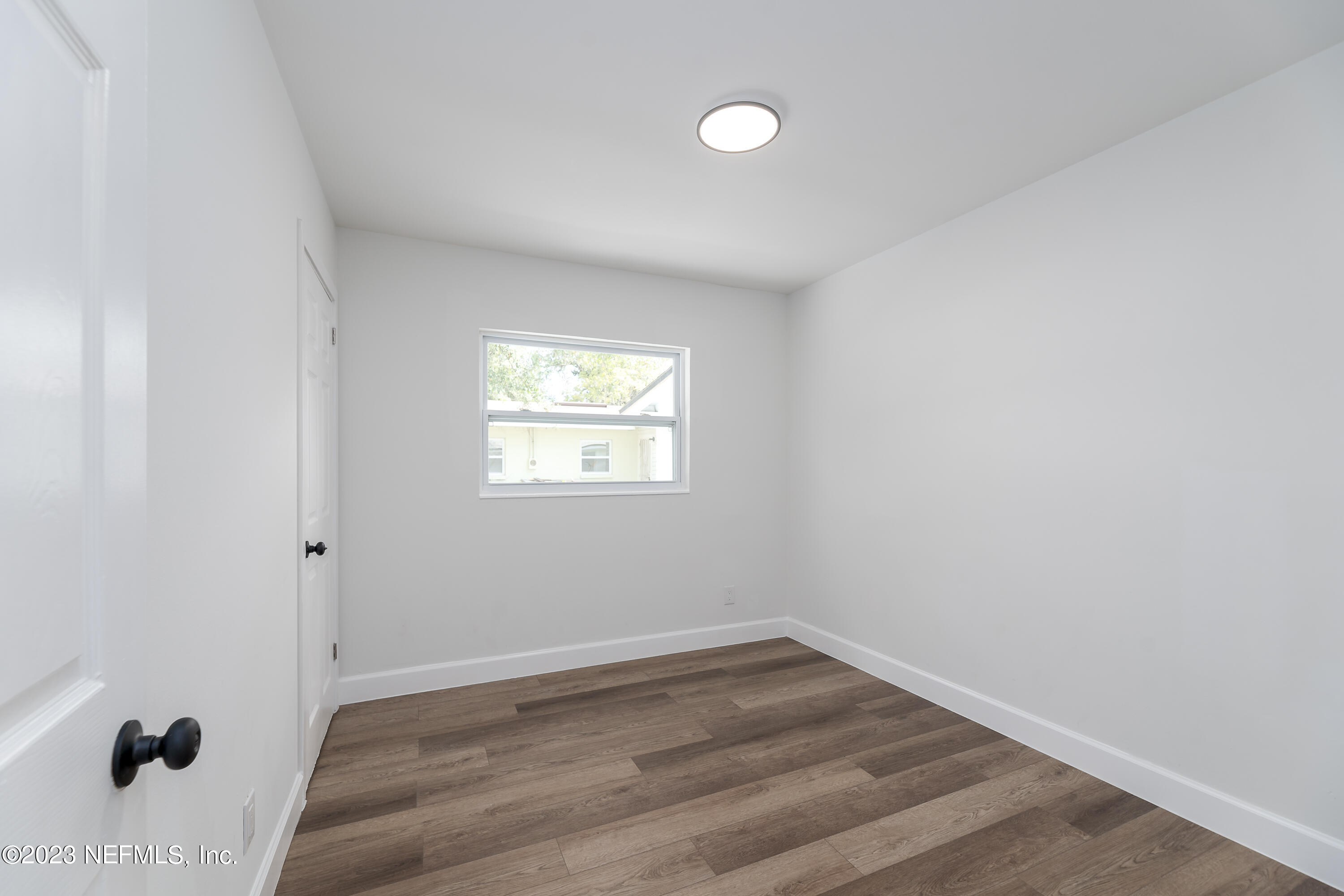 7425 Centauri Road Jacksonville, FL 32210 - Photo 14 of 23 a view of an empty room with wooden floor and a window