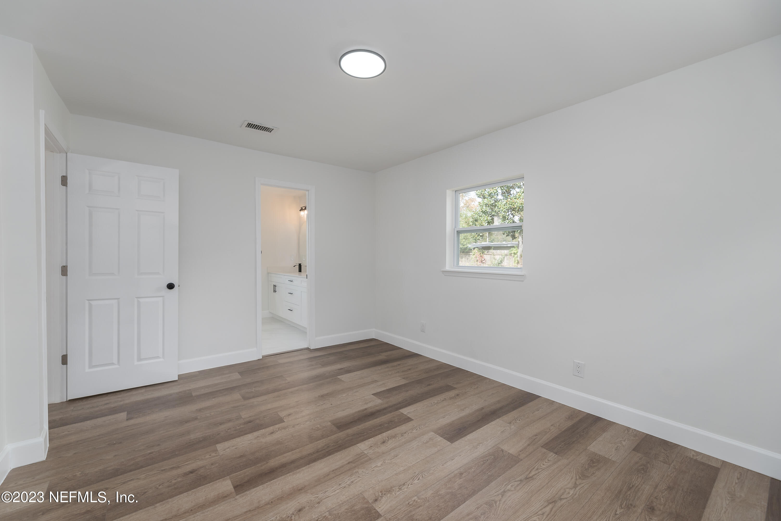 7425 Centauri Road Jacksonville, FL 32210 - Photo 16 of 23 an empty room with wooden floor and windows