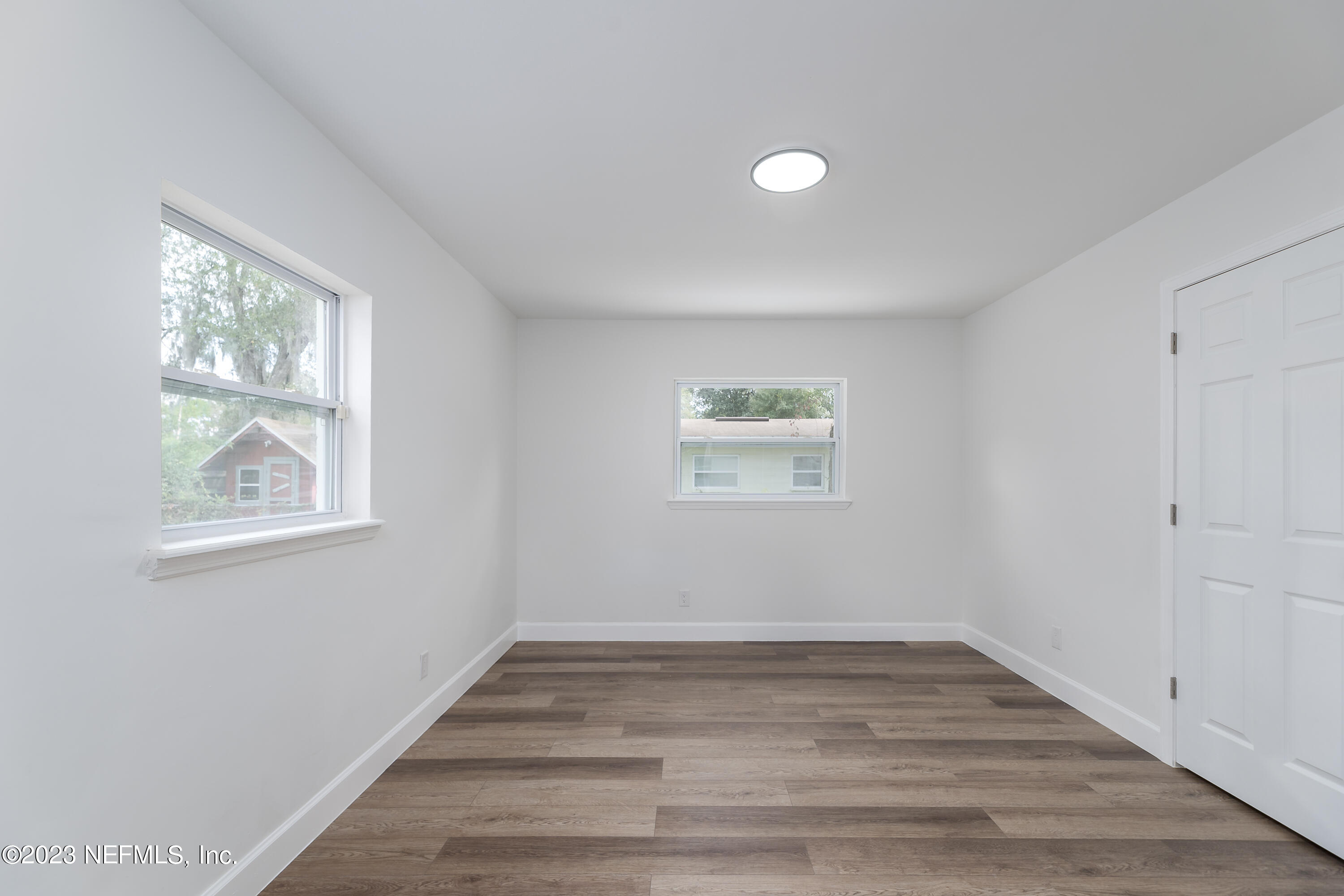 7425 Centauri Road Jacksonville, FL 32210 - Photo 17 of 23 a view of an empty room with wooden floor and a window